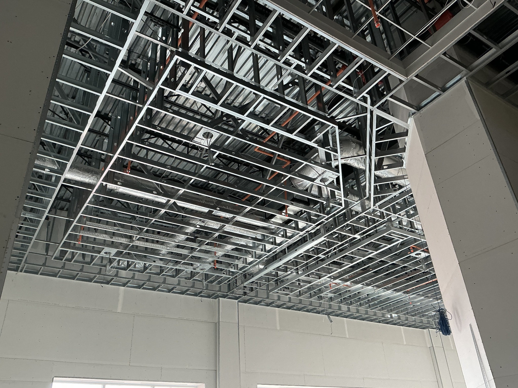 Detailed view of metal ceiling framing and installed drywall walls