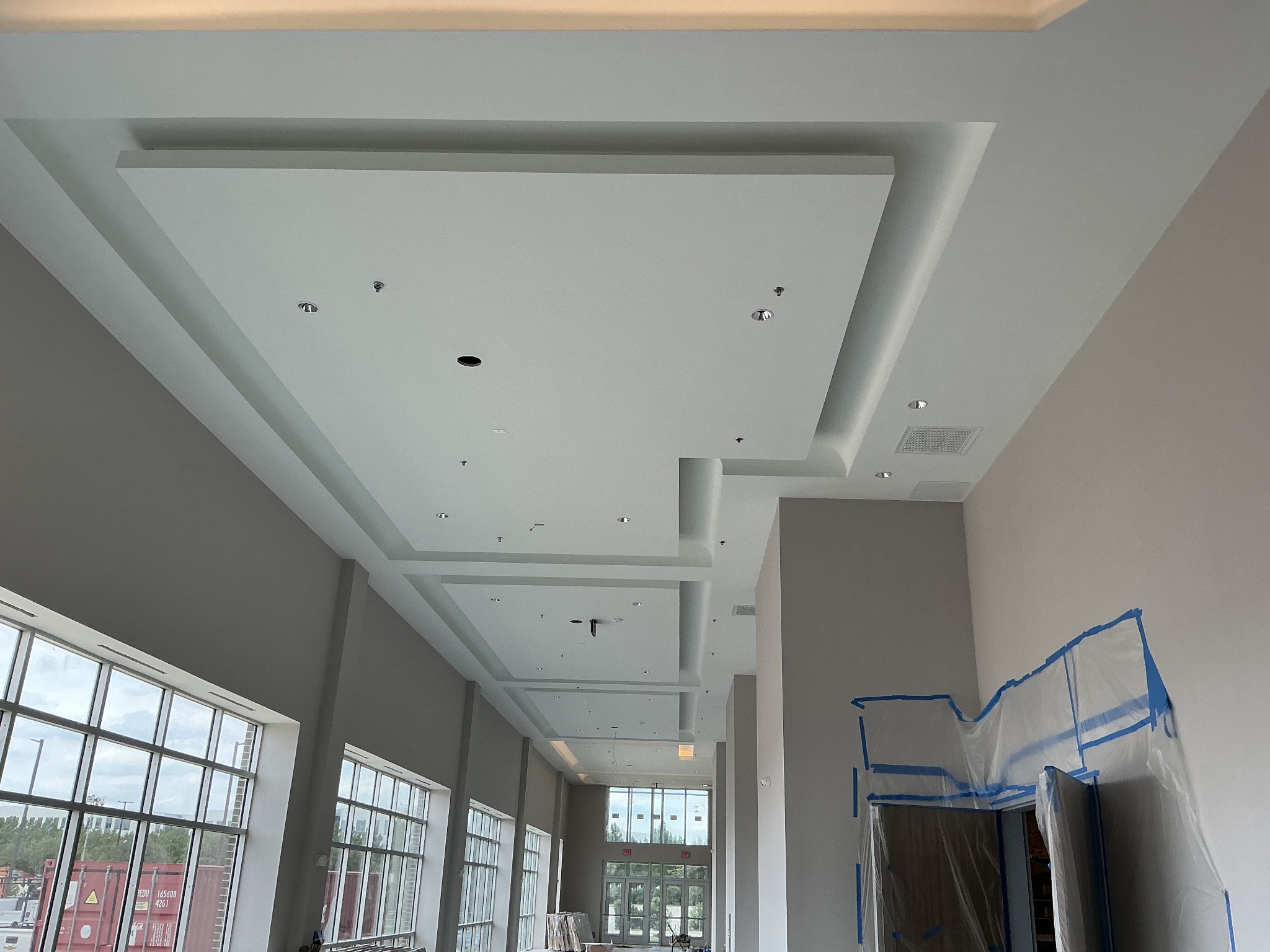 Finished drywall walls and recessed ceilings along a corridor